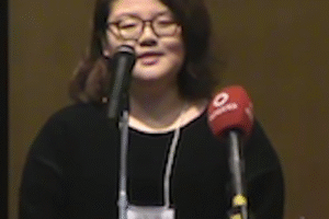 Student speaking at podium with microphones