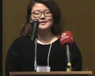 Student speaking at podium with microphones