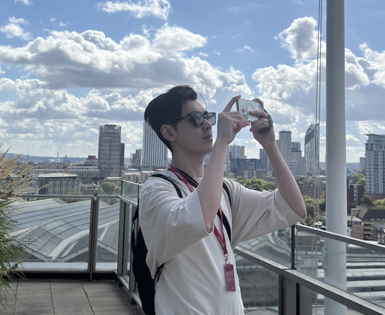 Dylan taking a photo against a city backdrop.