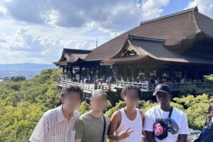 Julian and friends (with blurred faces) standing in front of a pagoda.