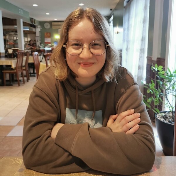 Leilah with arms crossed smiles for the camera