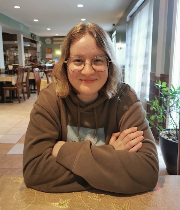 Leilah with arms crossed smiles for the camera