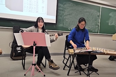 Japanese TA playing guitar and performer playing the kota