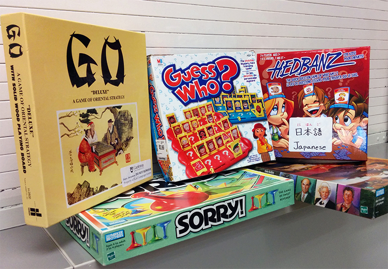 Stack of board games including: Go, Sorry, Guess Who, and Hedbanz