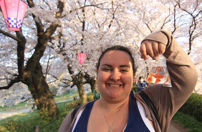 Mira holds up a bag of water with goldfish swimming around inside.