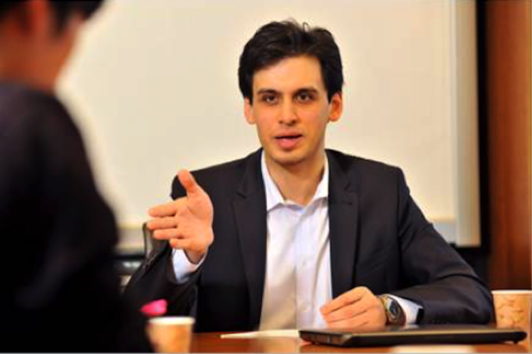 Yahor seated at a table in a business meeting