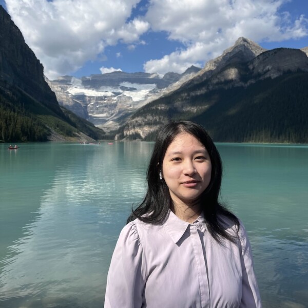 Maggie in front of Lake Louise with mountains and blue skies.