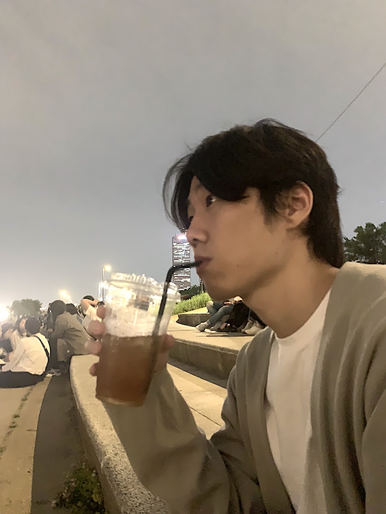 Seungjun drinking a bubble tea at an evening sports event