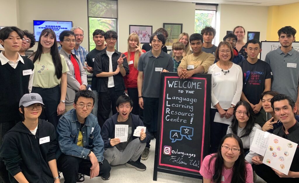 Group of students gathered around "Welcome to the Language Learning Resource Centre" sign.
