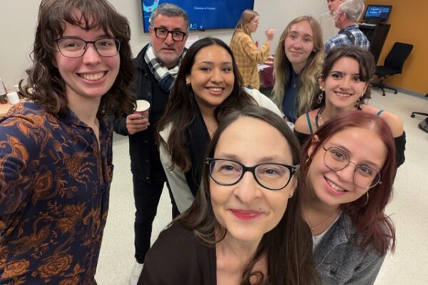 Cristina, Carlos, and a group of students smile for the camera