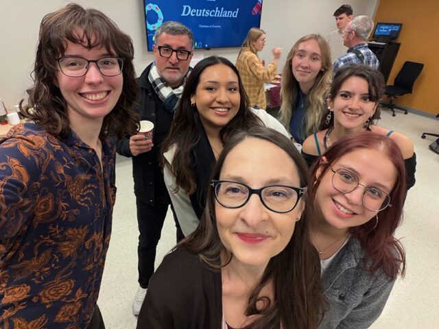 Cristina, Carlos, and a group of students smile for the camera