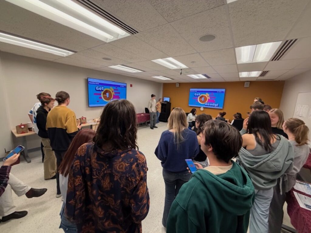 Group of students playing online quiz game.  Questions are projected on the screen.