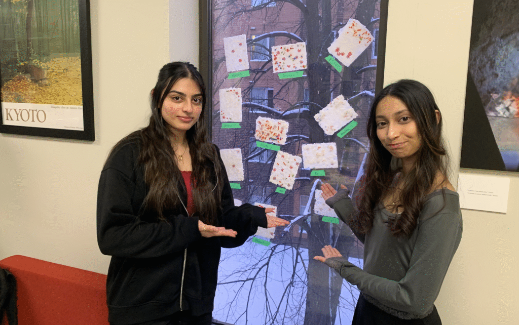 Two members of Sakura Society point toward the washi stuck on the window pane.