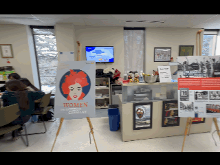 Walk-thru of poster exhibit shows posters on tripods and student work on whiteboards