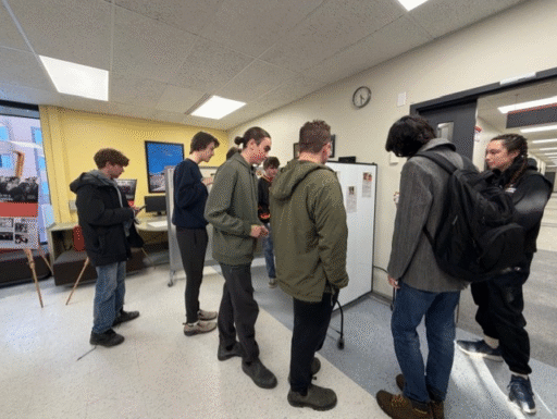 Group of students mingle around poster presentation