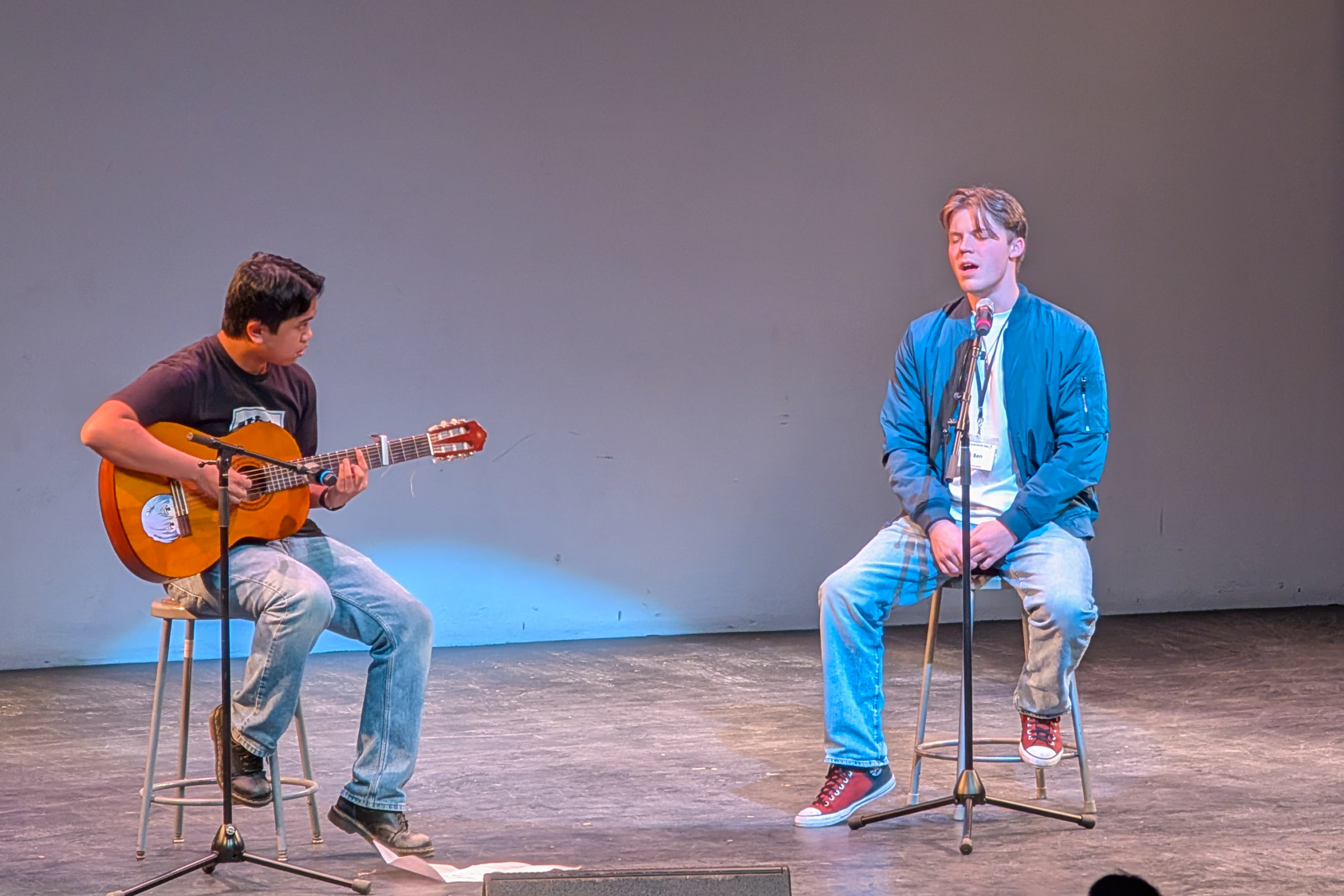 Jacob plays acoustic while Ben sings.  Both are seated on stools.