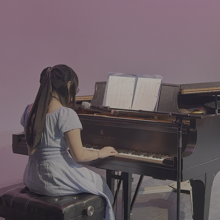 Cobra seated at a piano in a blue dress.