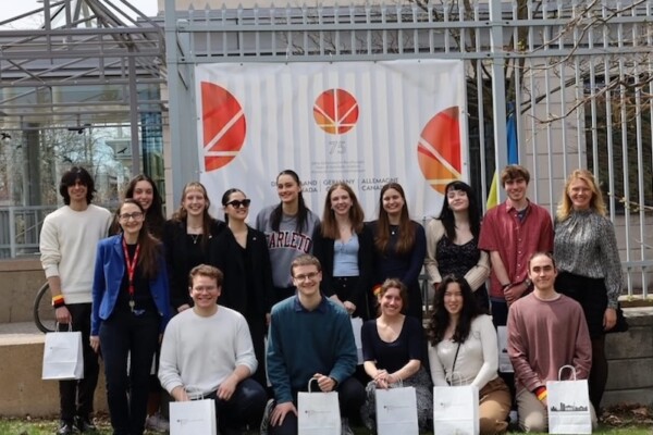 Group of students in front of Germany at 75 poster.