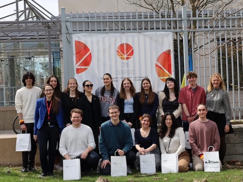 Group of students in front of Germany at 75 poster.
