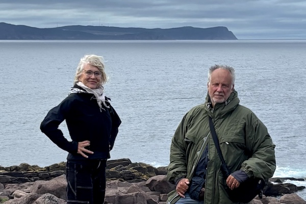 Couple poses on a rocky outcropping in front of the Atlantic.