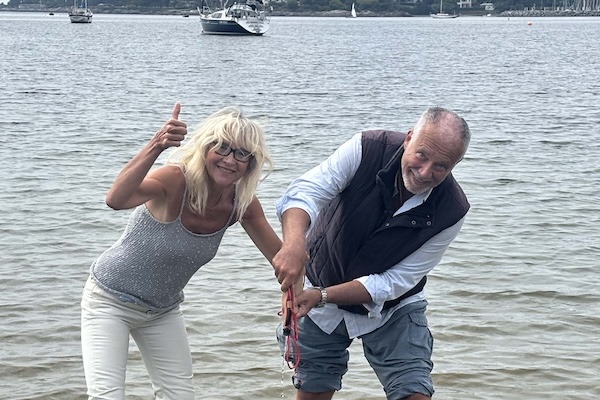 Couple wading into the harbour in Victoria, BC to pour water from the Atlantic into the Pacific.