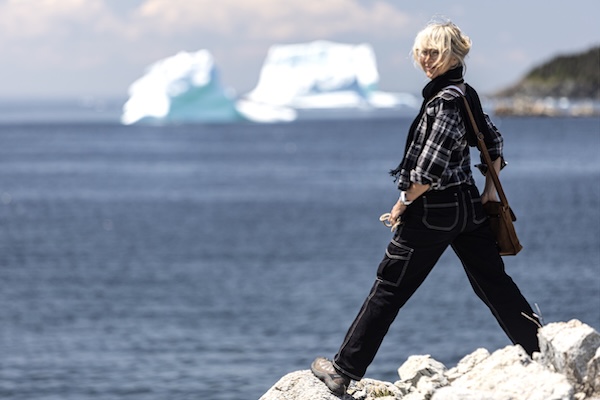 c Arianna on the shoreline with an iceberg in the background.
