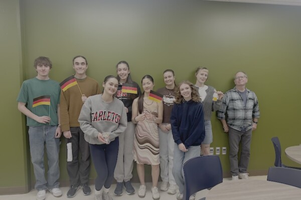 Group of certificate exam takers holding German flags
