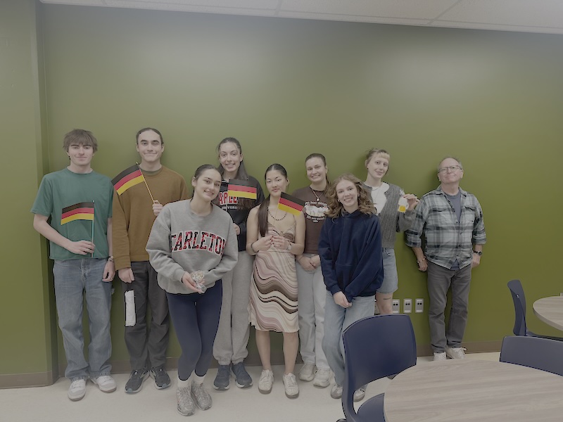 Group of certificate exam takers holding German flags