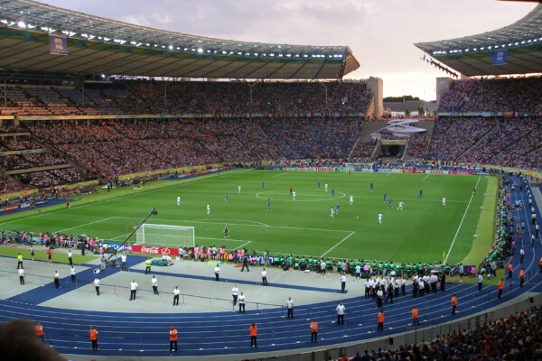 Soccer field as seen from the stands. Crowds in seats. Players on field.