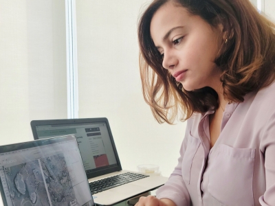 A female graduate student, Rafaela is working on a laptop