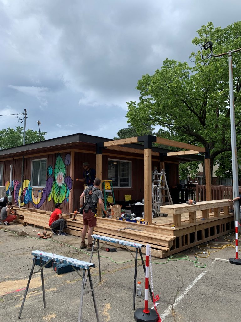 Several people building a wooden structure