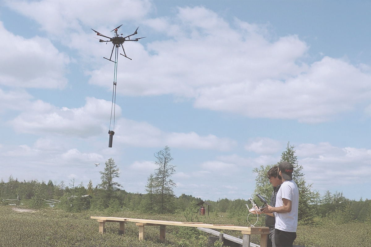 Two people operating a drone over the Mer Bleue Bog.