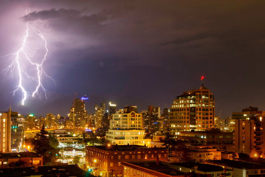 A lightning strike over city buildings.