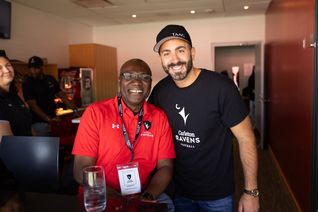 Carleton President Wisdom Tettey poses with a Panda game attendee.