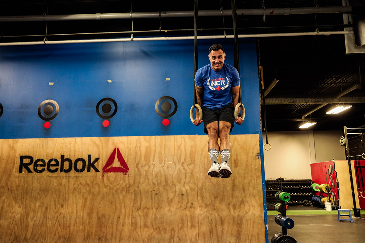 Reza Mashkoori performs a ring exercise inside CrossFit NCR, showcasing strength and athleticism.