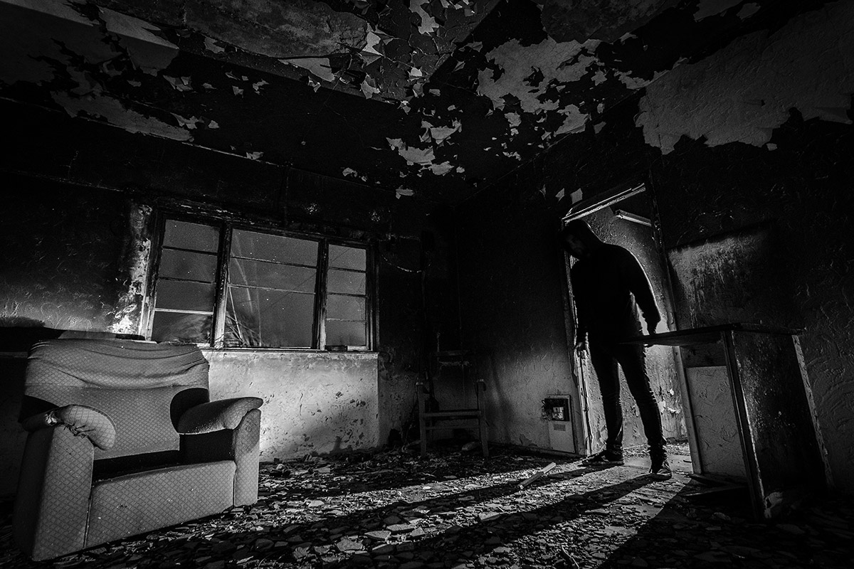 Faceless silhouette in a dark doorway — symbolizing Indigenous erasure, stereotypes, and horror in modern storytelling.