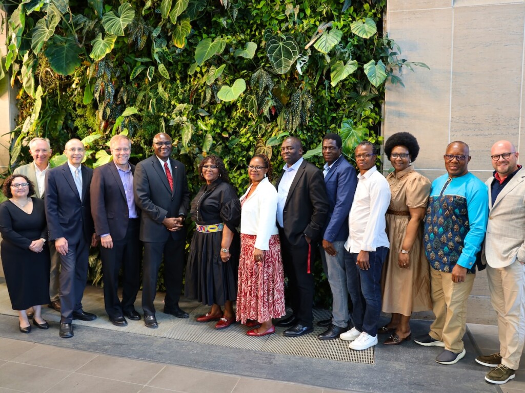 A large group of people posing for a photo in front of a wall.