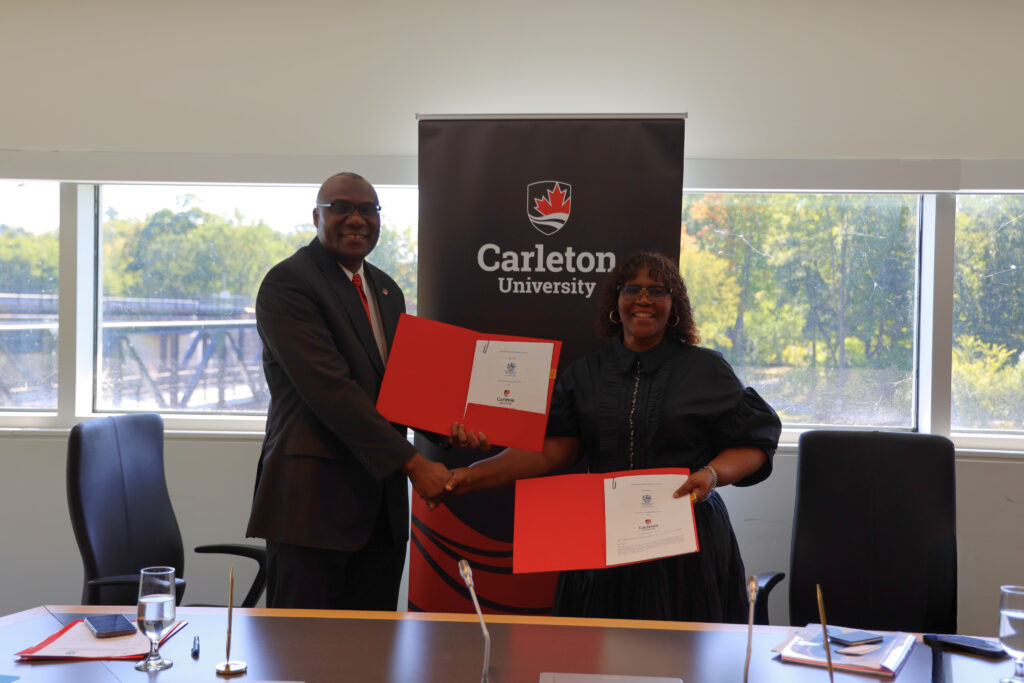 Carleton University President Wisdom Tettey and University of Zululand Vice-Chancellor Xoliswa A. Mtose holding up signed MOU