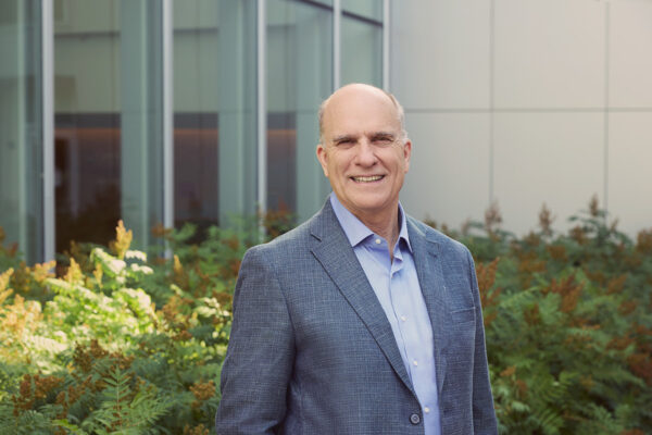 A man in a suit smiles for the camera.