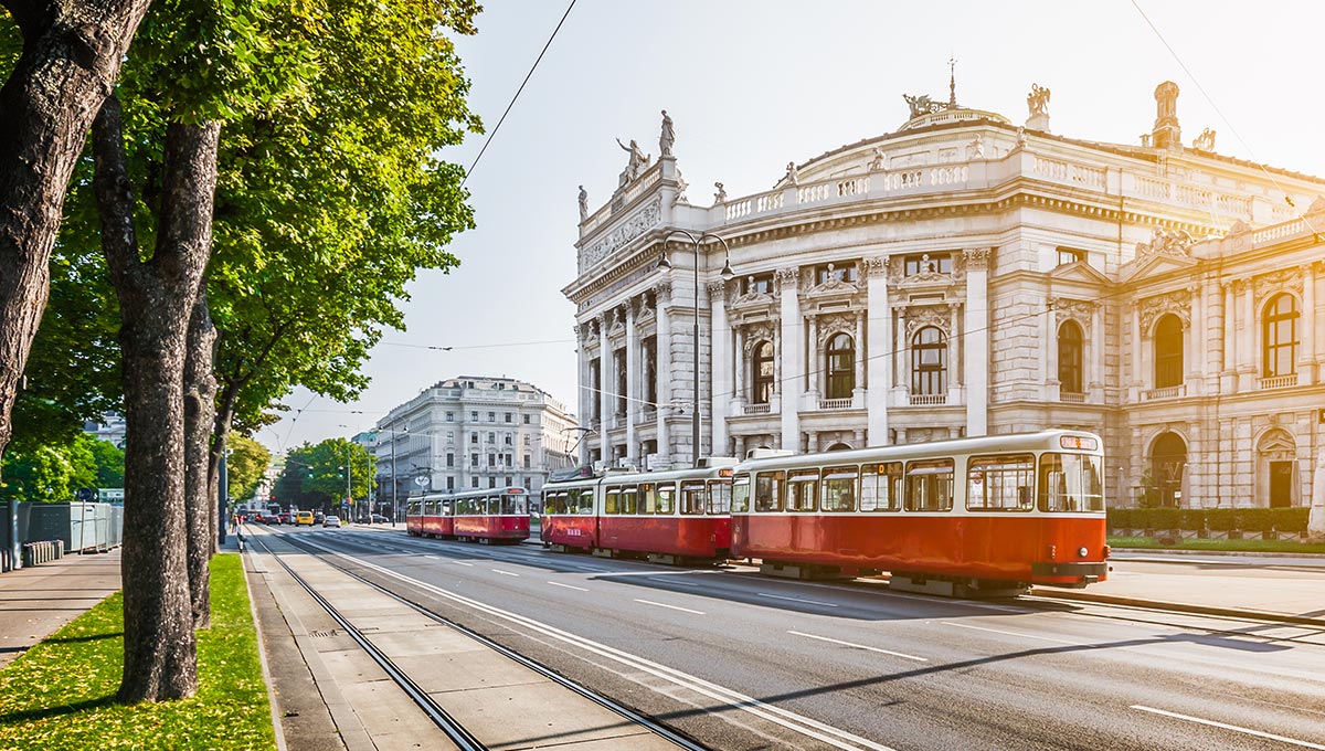 A traditional red electric tram at sunrise with retro vintage Instagram style filter effect in Vienna, Austria.
