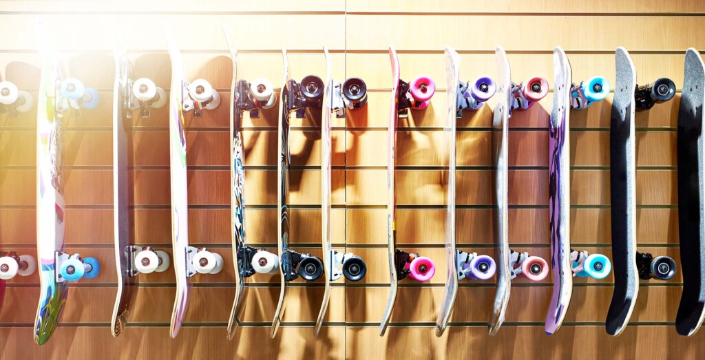 A row of skateboards hanging from a wall.