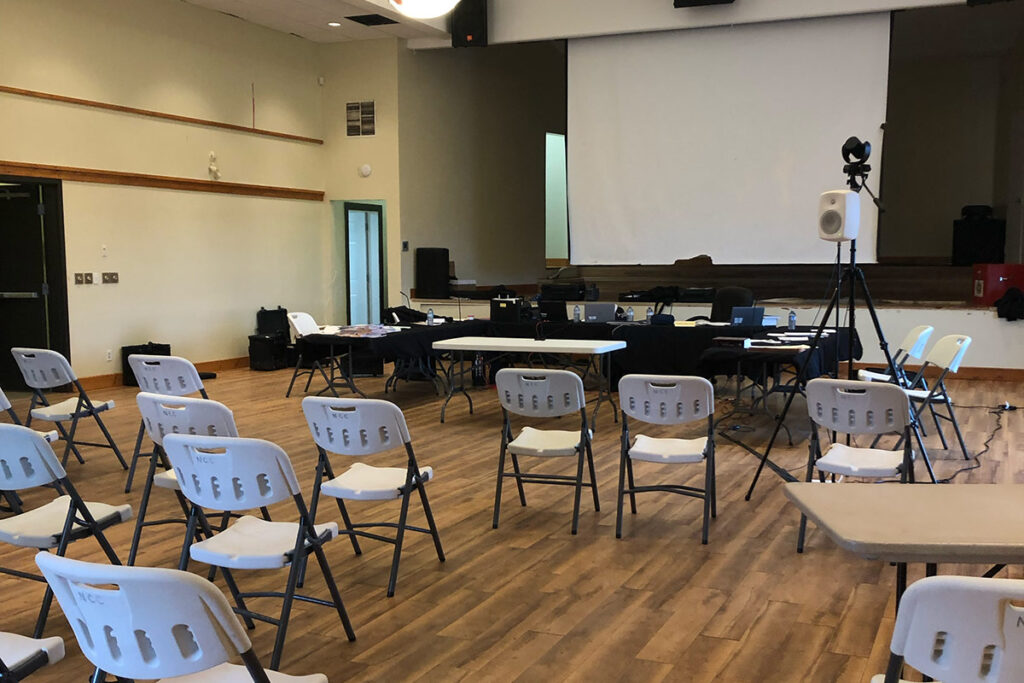 Several chairs and a projector in a large community centre room.