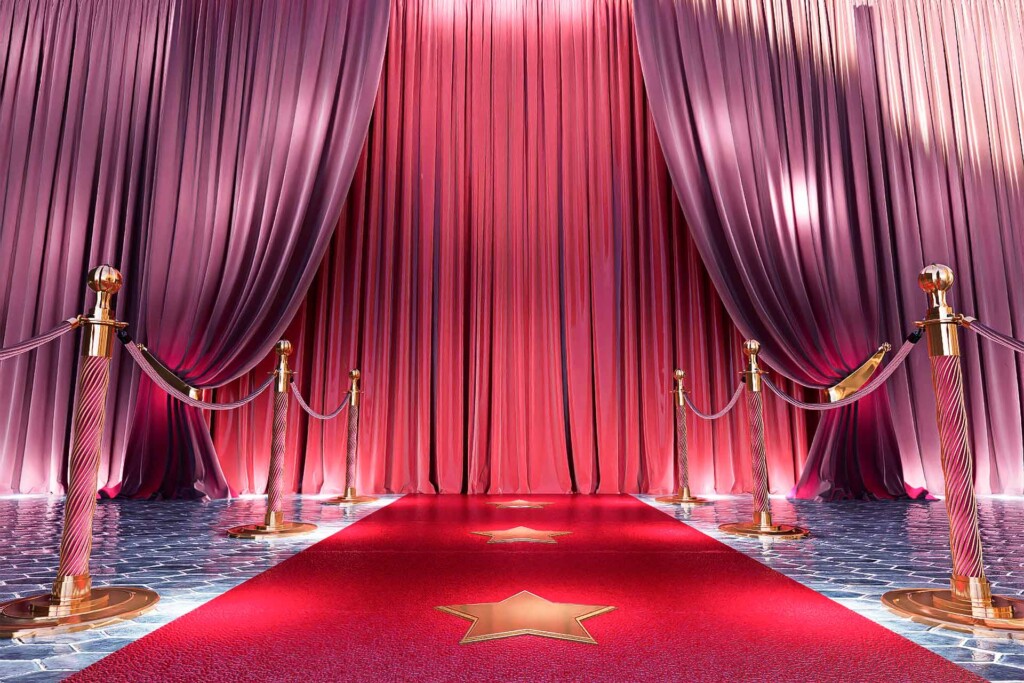 Red carpet with golden barriers leading to red silk curtains.