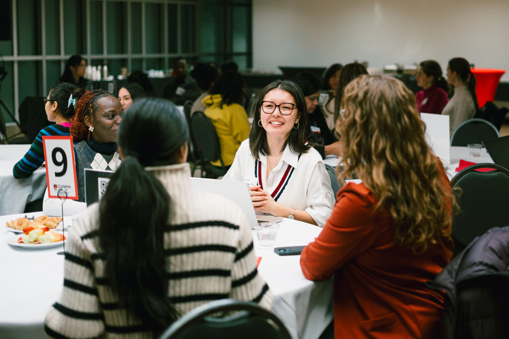 Women chat around a table at a STEM mentorship event