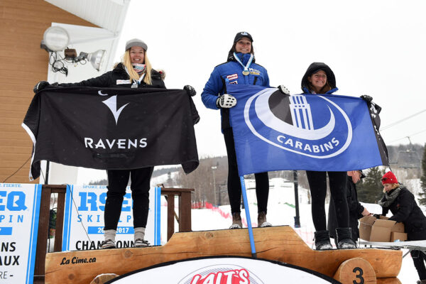 Three athletes accepting medals on a podium.