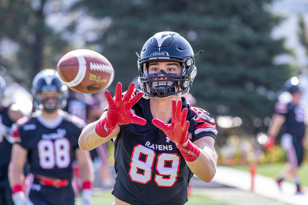 A football player prepares to catch a football during a 2019 university level game.