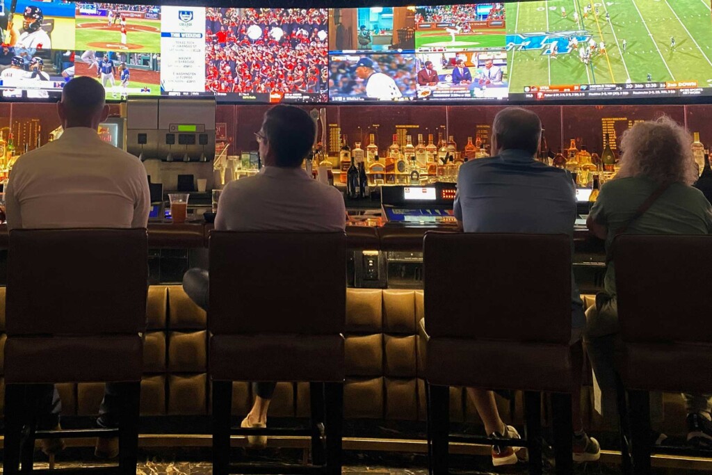 Four patrons at a bar for sports betting.