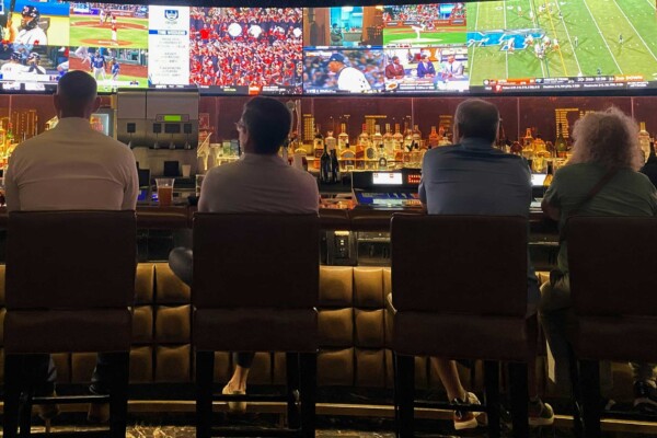 Four patrons at a bar for sports betting.