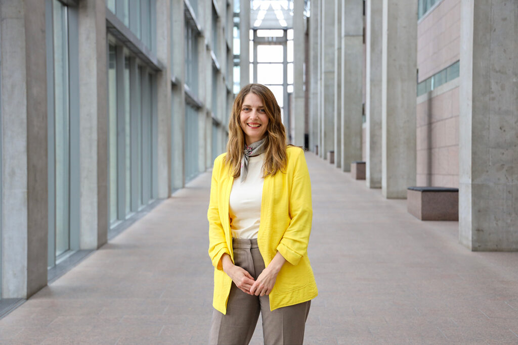 Catherine Sinclair poses for a photo in front of a long hallway.