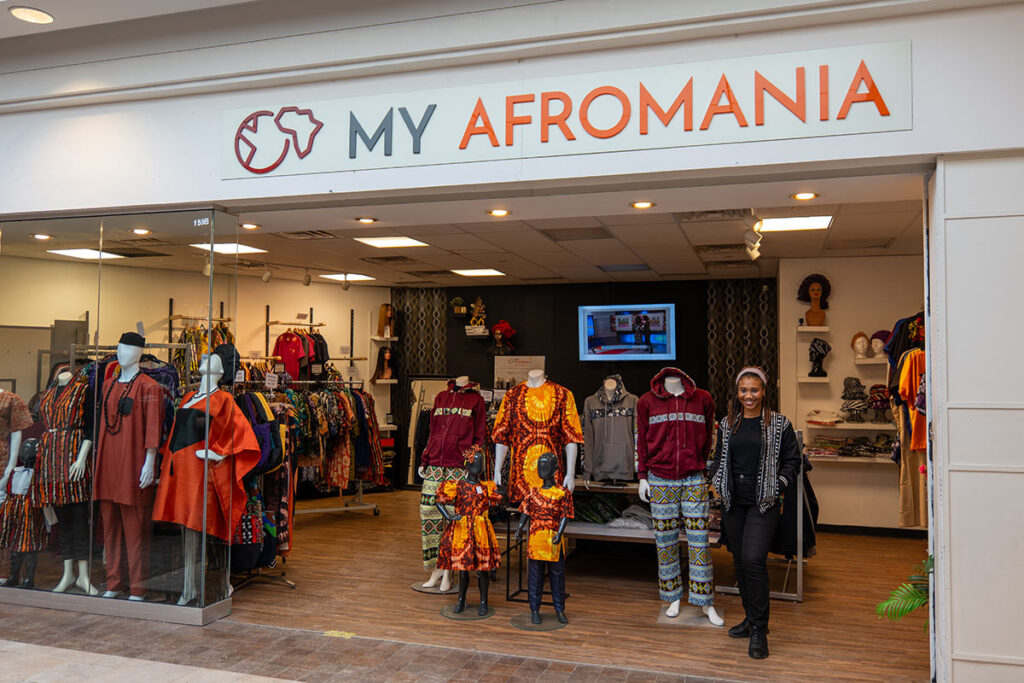 A woman stands in front of a clothing store.